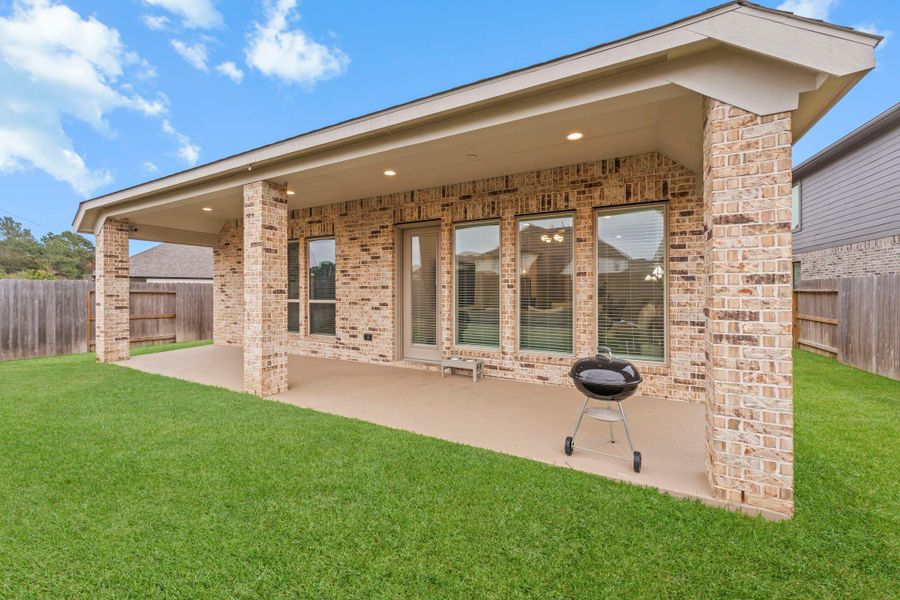 This expansive covered porch with recessed lighting covers the width of the home and easily accommodates living and dining furnishings, creating an ideal extension of the home’s entertaining spaces.