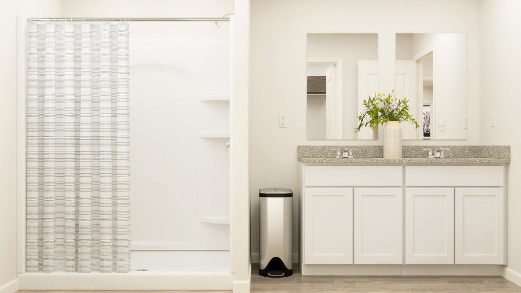 A white kitchen with a black trash can and a white cabinet.