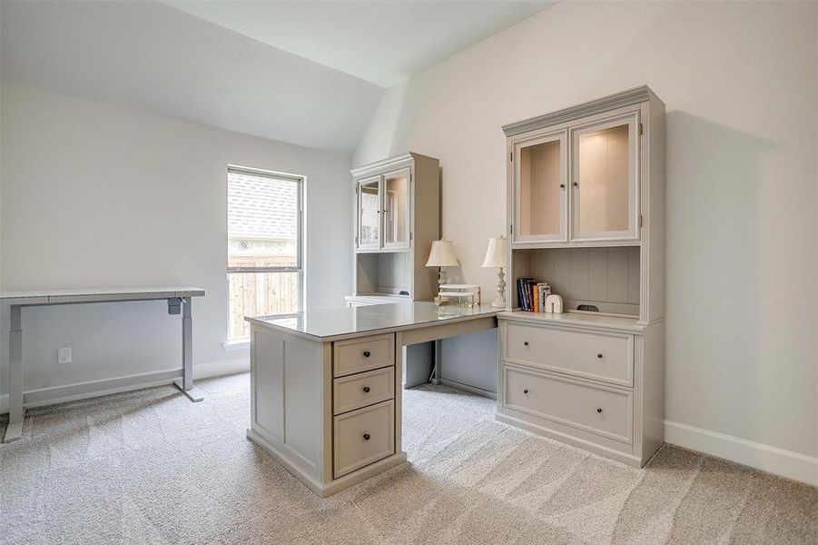 Office featuring light colored carpet, lofted ceiling, and baseboards Office featuring light colored carpet, lofted ceiling, and baseboards