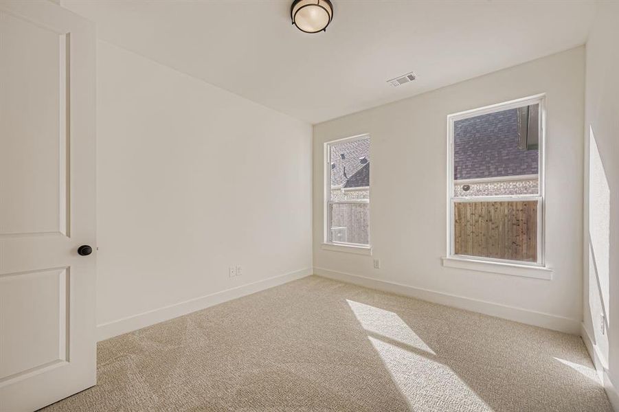 Carpeted spare room featuring baseboards