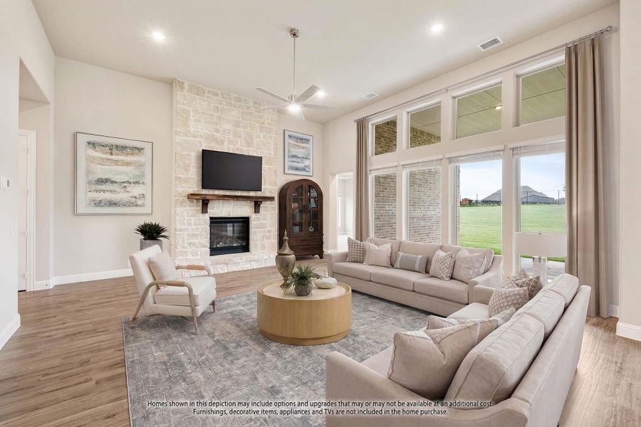 Living room with stone fireplace, high ceilings, large windows, and neutral sectional sofa on hardwood floors Living room with stone fireplace, high ceilings, large windows, and neutral sectional sofa on hardwood floors