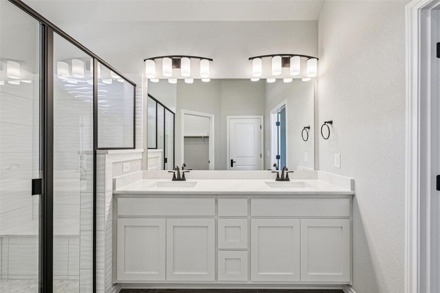 Bathroom featuring a shower stall and double vanity Bathroom featuring a shower stall and double vanity
