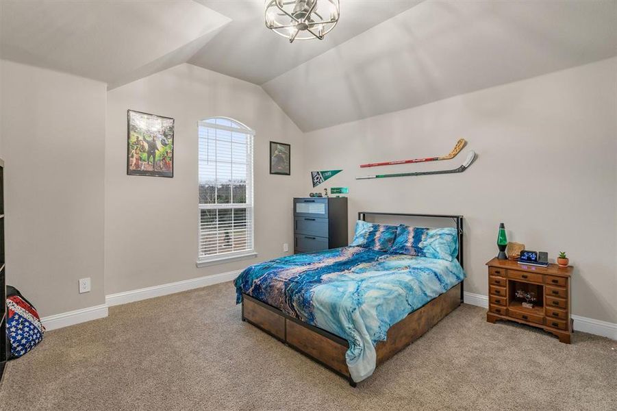 Carpeted bedroom featuring baseboards and suspended lighting