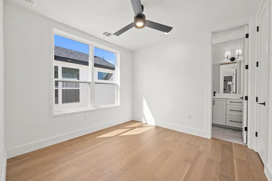 Unfurnished bedroom featuring light wood-style flooring, a ceiling fan, and ensuite bathroom Unfurnished bedroom featuring light wood-style flooring, a ceiling fan, and ensuite bathroom
