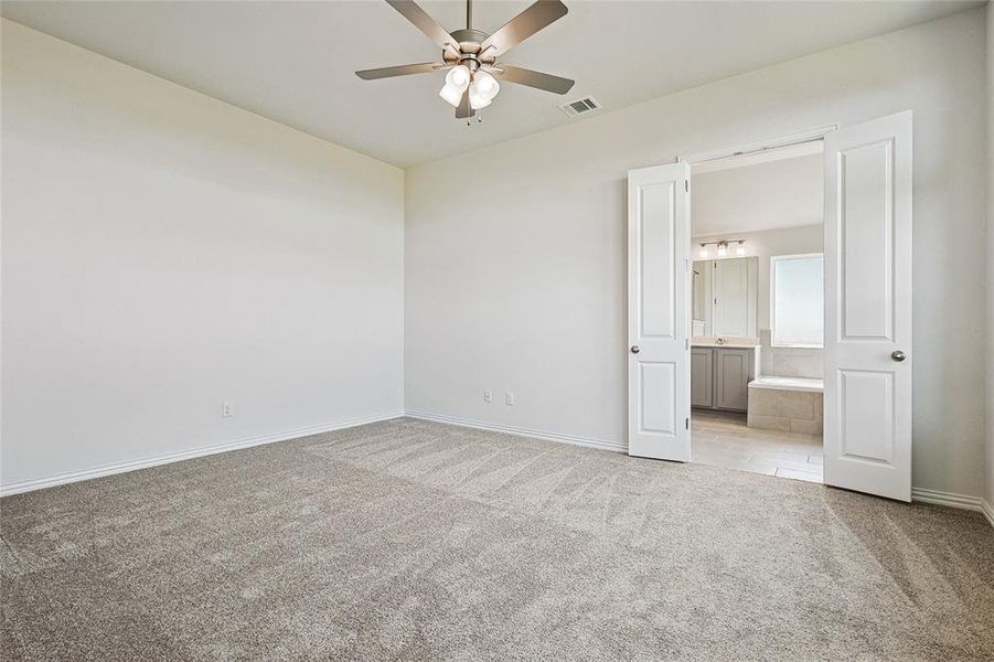 Carpeted empty room featuring ceiling fan