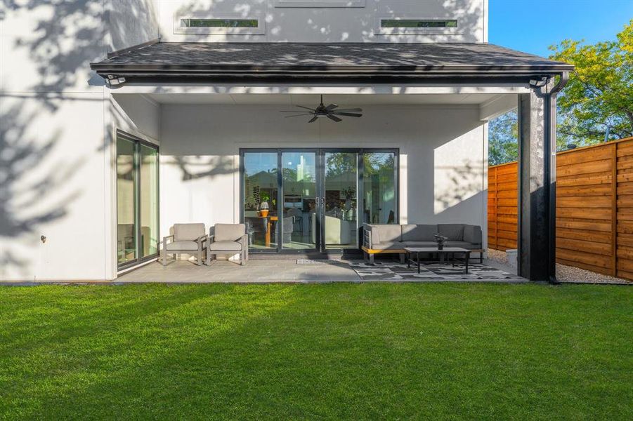 Rear view of property featuring covered patio with ceiling fan. Rear view of property featuring covered patio with ceiling fan.