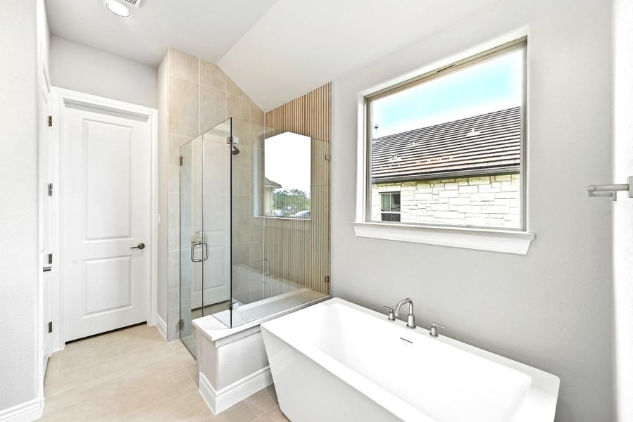 Contemporary bathroom featuring a freestanding soaking tub, a glass-enclosed shower with tiled walls, and a large window