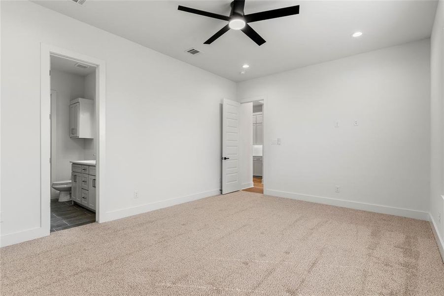 Unfurnished bedroom featuring dark carpet, connected bathroom, a ceiling fan, and recessed lighting Unfurnished bedroom featuring dark carpet, connected bathroom, a ceiling fan, and recessed lighting