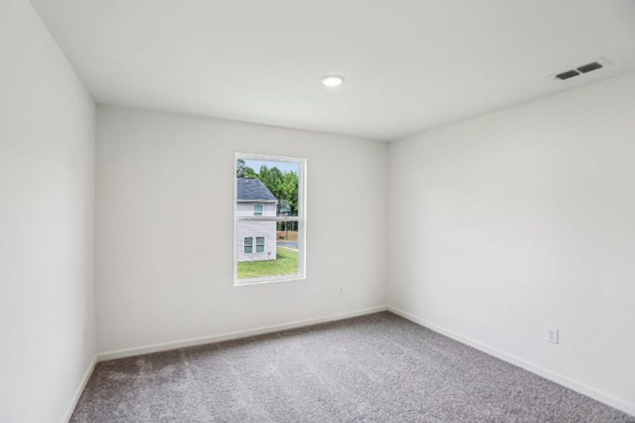 A room with a window and a carpet.