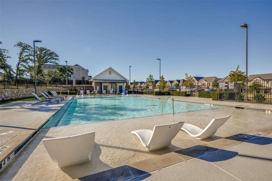 Community pool with a patio and a residential view Community pool with a patio and a residential view