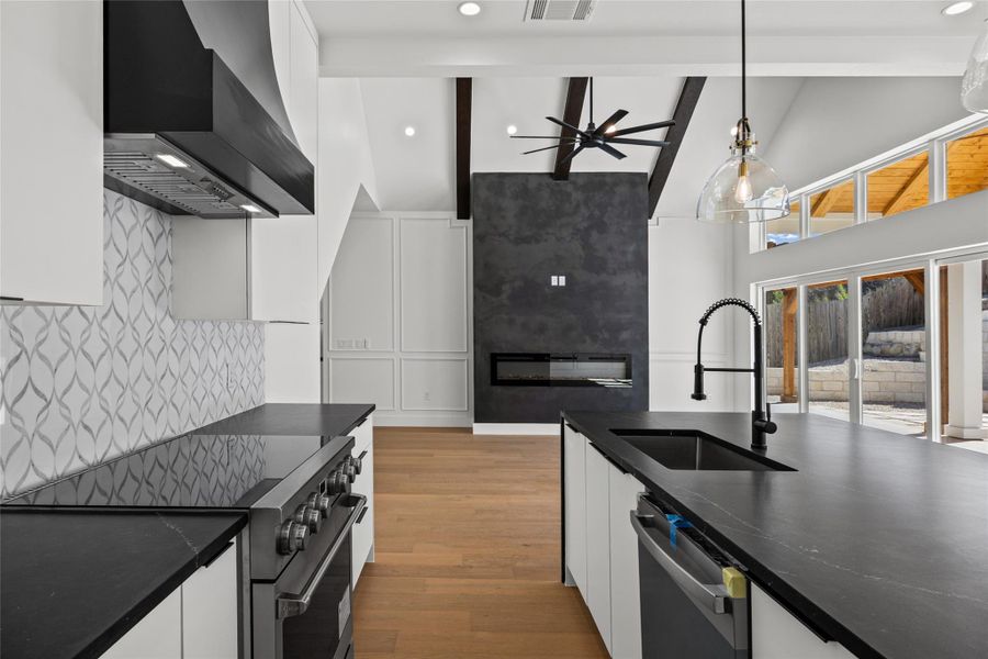 Kitchen with stainless steel appliances, white cabinetry, light wood-style flooring, ceiling fan, and pendant lighting Kitchen with stainless steel appliances, white cabinetry, light wood-style flooring, ceiling fan, and pendant lighting