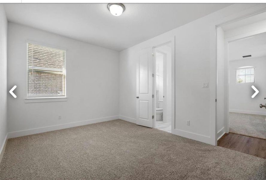 Unfurnished bedroom with carpet flooring and connected bathroom
