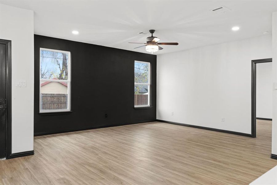 Living room featuring ceiling fan, plenty of natural light, and light hardwood / wood-style floors