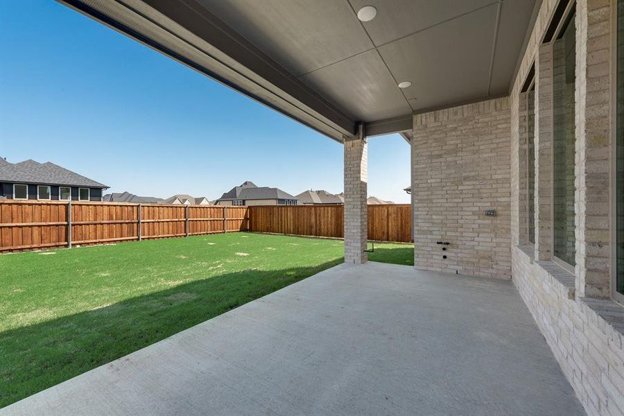 Fenced backyard with a patio area and a residential view Fenced backyard with a patio area and a residential view