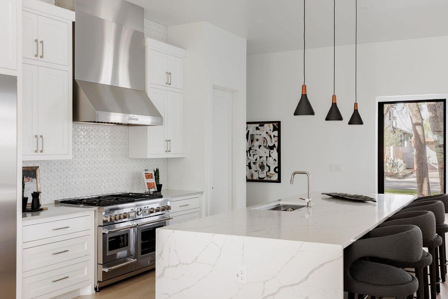 Another view of the kitchen highlights the warmth of custom cabinetry, sleek stone countertops, and thoughtfully integrated appliances, all designed for the culinary enthusiast. Another view of the kitchen highlights the warmth of custom cabinetry, sleek stone countertops, and thoughtfully integrated appliances, all designed for the culinary enthusiast.
