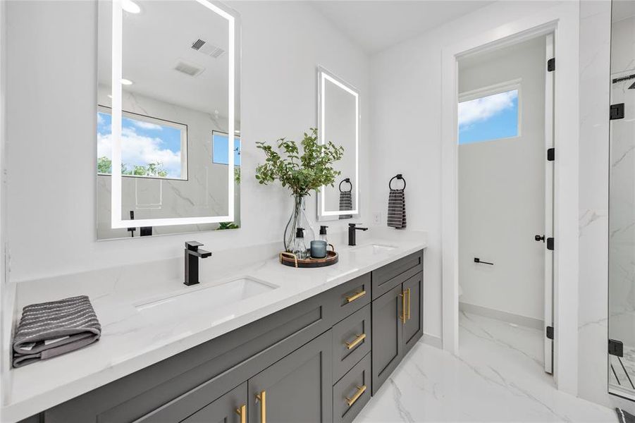 Elegant primary ensuite bathroom with dual vanities