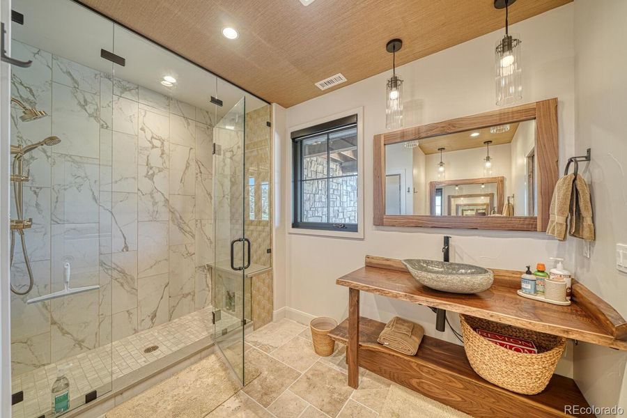 A spa-quality bath with dual black walnut vanities, a large walk-in shower, and a private water closet. A spa-quality bath with dual black walnut vanities, a large walk-in shower, and a private water closet.
