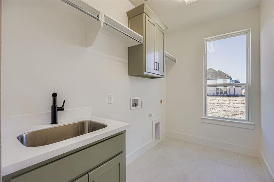 Laundry room featuring hookup for a gas dryer, hookup for a washing machine, cabinet space, light tile patterned floors, and electric dryer hookup Laundry room featuring hookup for a gas dryer, hookup for a washing machine, cabinet space, light tile patterned floors, and electric dryer hookup
