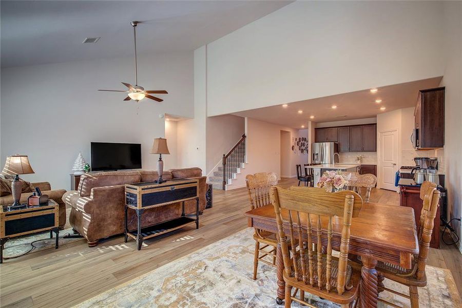 Dining room featuring light hardwood / wood-style flooring, high vaulted ceiling, and ceiling fan