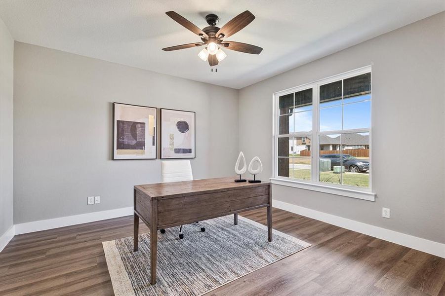 Home office featuring dark hardwood / wood-style flooring and ceiling fan