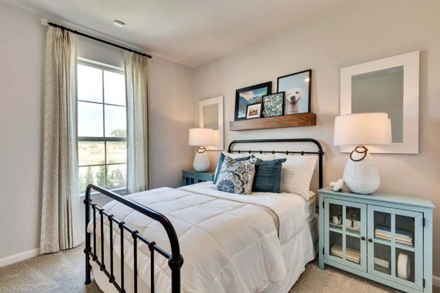 Bedroom with baseboards and light colored carpet