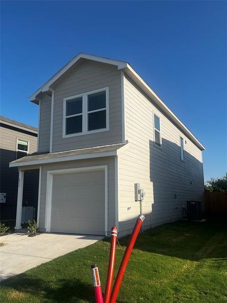 Two-story residence featuring light-toned horizontal siding, a single-car garage, and a concrete driveway Two-story residence featuring light-toned horizontal siding, a single-car garage, and a concrete driveway
