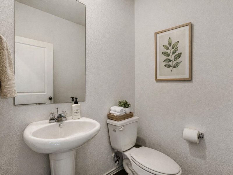 Half bath featuring a textured wall