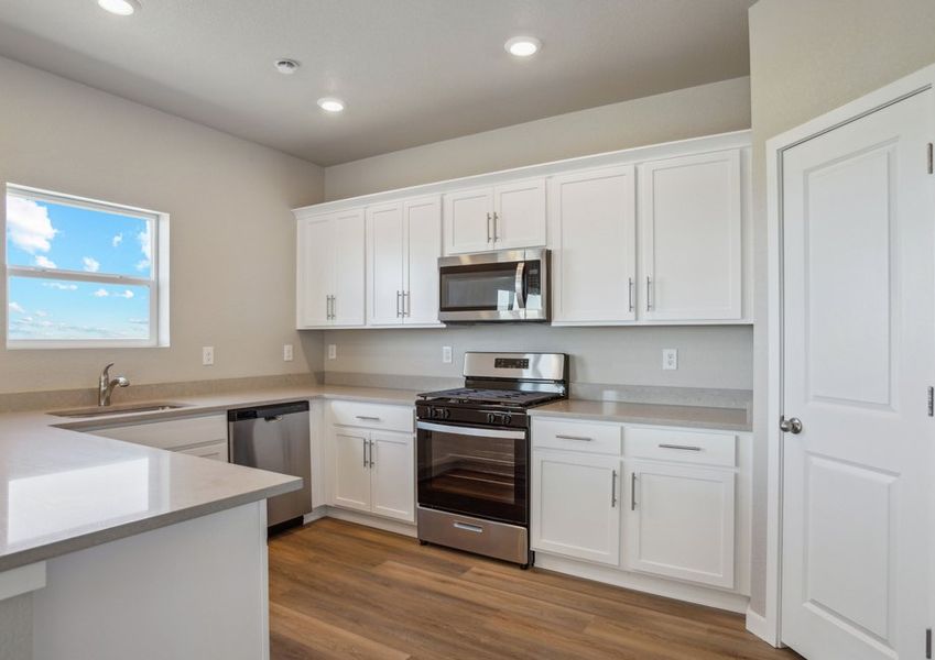 The kitchen has stainless steel appliances and white cabinets