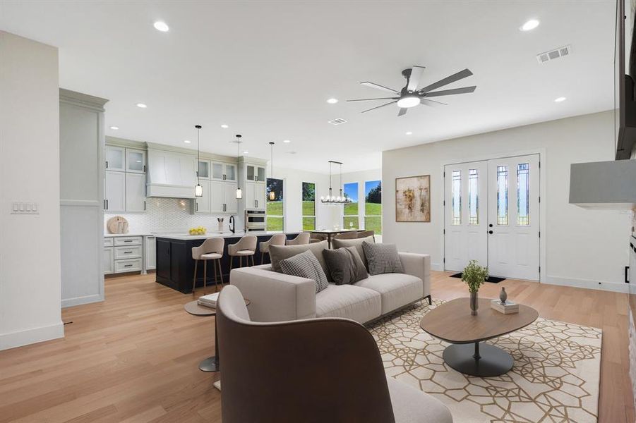 Expansive open-concept living space featuring wood-finish flooring, recessed lighting, and a contemporary ceiling fan Expansive open-concept living space featuring wood-finish flooring, recessed lighting, and a contemporary ceiling fan