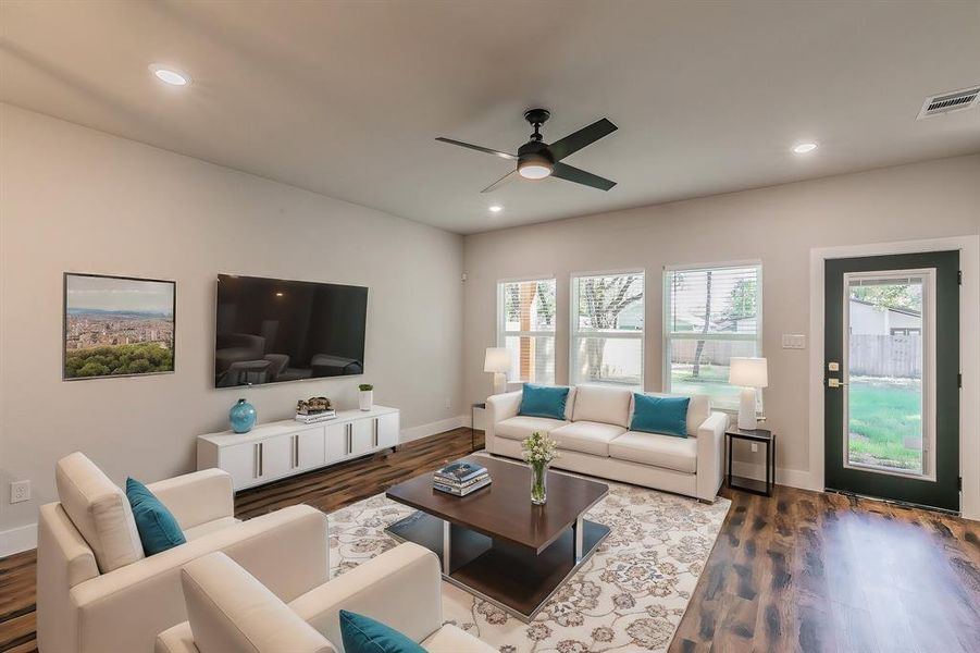 Living room featuring ceiling fan and dark wood-type flooring