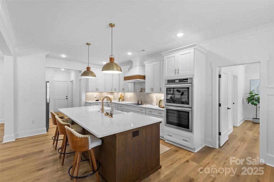 *representative photo- gourmet kitchen w/ custom wood hood vent, double oven, microwave built into the island, oversized level 3 quartz countertops, porcelain farmhouse sink