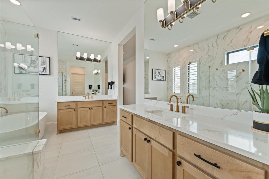 The spa-inspired primary bath delivers luxury and functionality with designer finishes, dual vanities, an oversized walk-in shower, and generous storage.