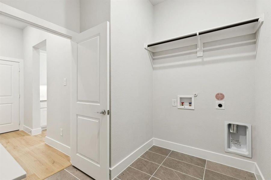 Laundry area featuring hookup for an electric dryer, hookup for a gas dryer, washer hookup, and light tile patterned flooring