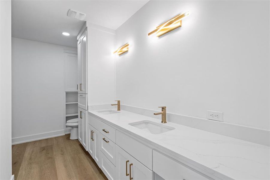 Full bathroom with double vanity, wood finished floors, and recessed lighting Full bathroom with double vanity, wood finished floors, and recessed lighting