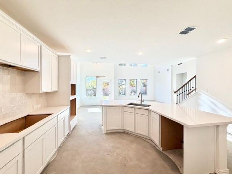 Kitchen with white cabinetry, concrete flooring, and recessed lighting
