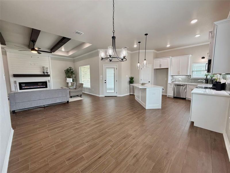 Kitchen with open floor plan, a chandelier, a glass covered fireplace, pendant lighting, and healthy amount of natural light Kitchen with open floor plan, a chandelier, a glass covered fireplace, pendant lighting, and healthy amount of natural light