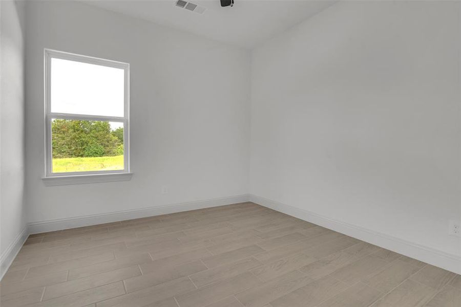Empty room with baseboards and light wood-style flooring Empty room with baseboards and light wood-style flooring