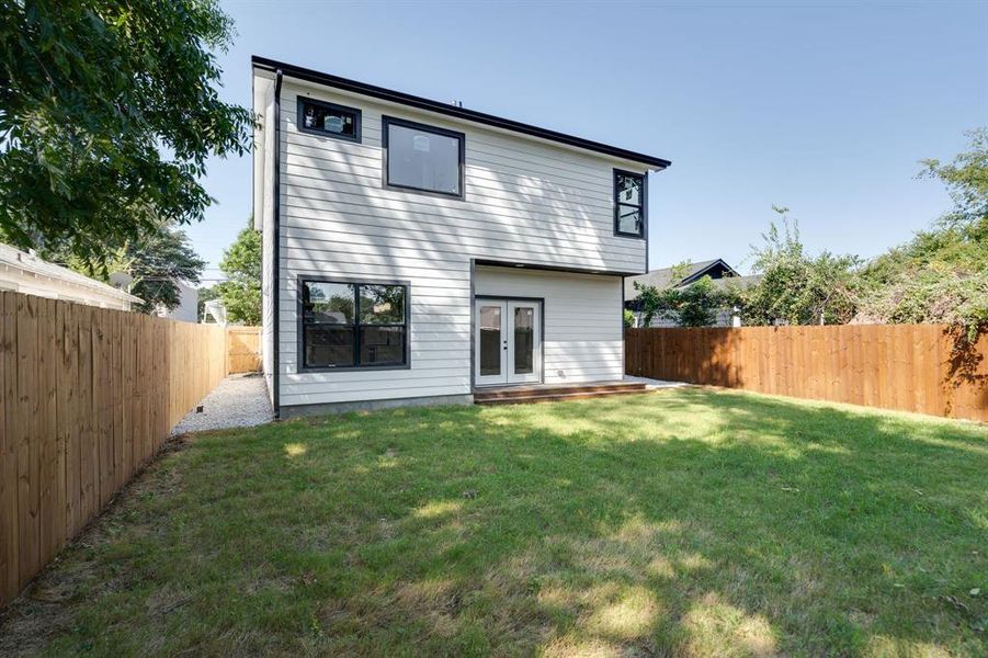 Back of property with a yard and french doors