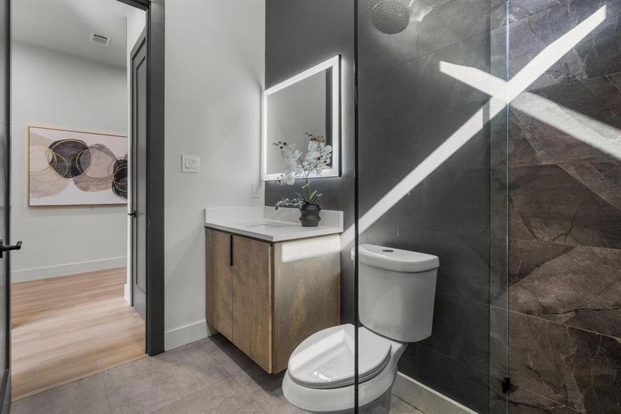 Full bath featuring vanity, walk in shower, and light tile patterned floors
