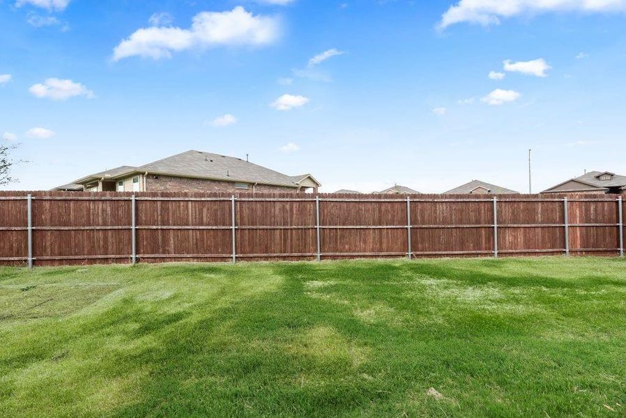 Expansive grass lawn featuring a wood privacy fence