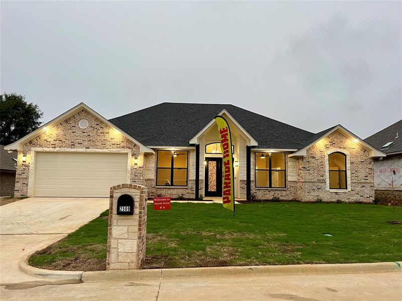 View of front of property with brick siding, concrete driveway, and a garage