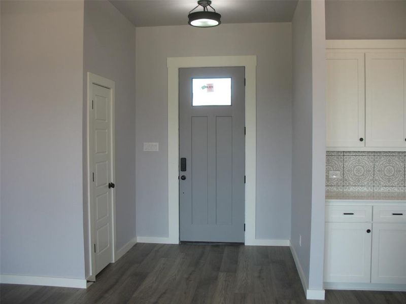 Entrance foyer with dark wood finished floors and baseboards