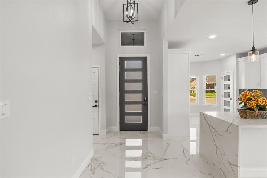 Foyer featuring a chandelier, light marble finish flooring, and recessed lighting