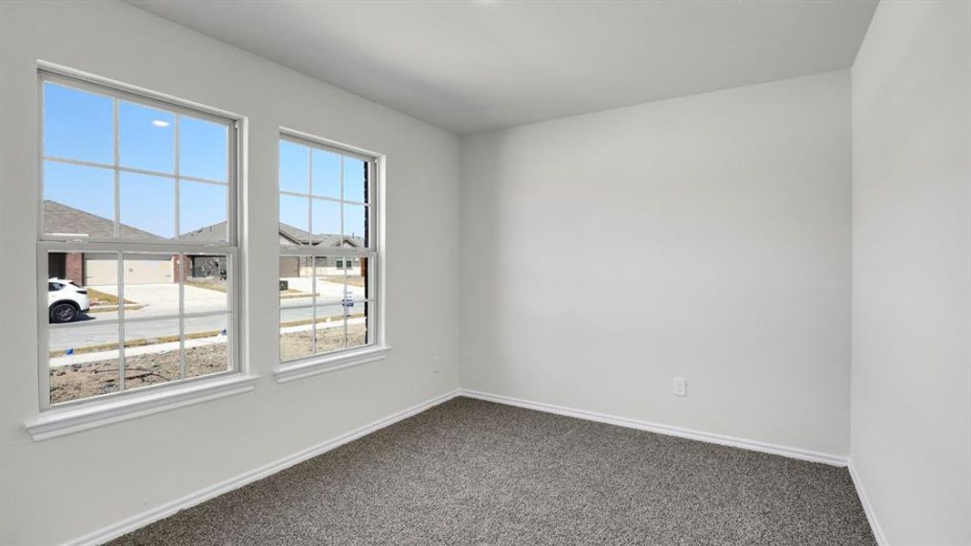 Empty room with baseboards and dark colored carpet