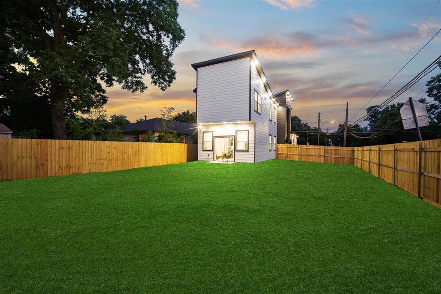 Rear view of house with a fenced backyard