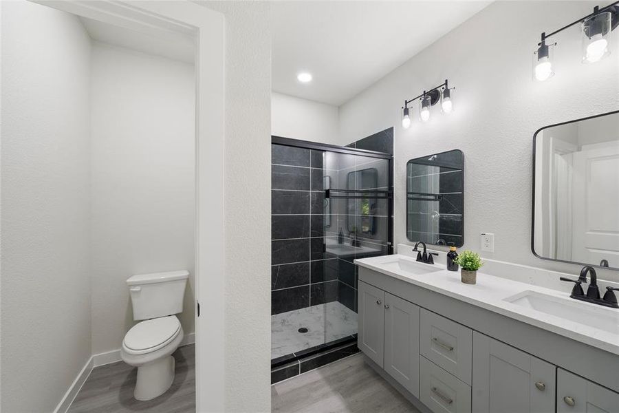 Bathroom with vanity, toilet, walk in shower, and hardwood / wood-style floors