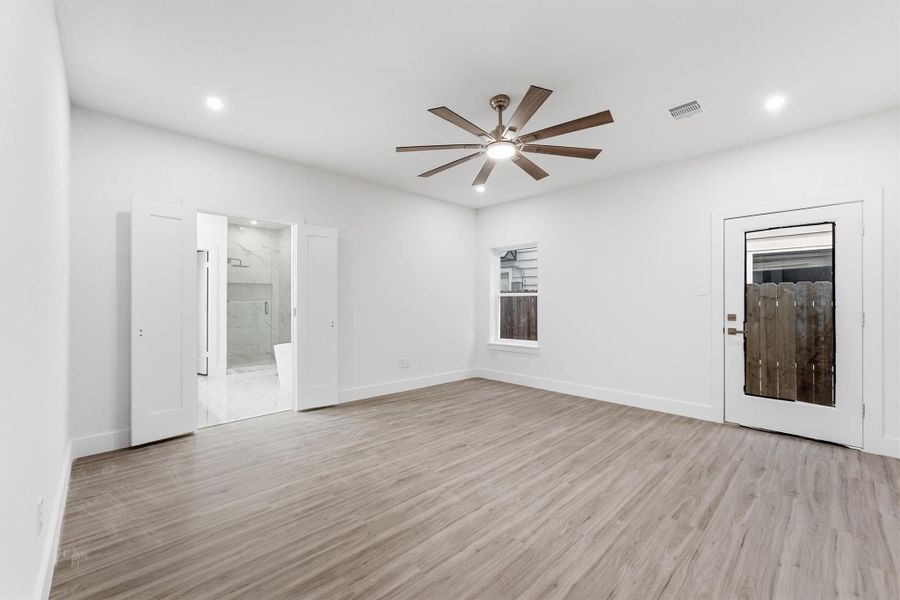 Private first-floor primary suite with wood-look flooring and direct access to the en-suite bath.