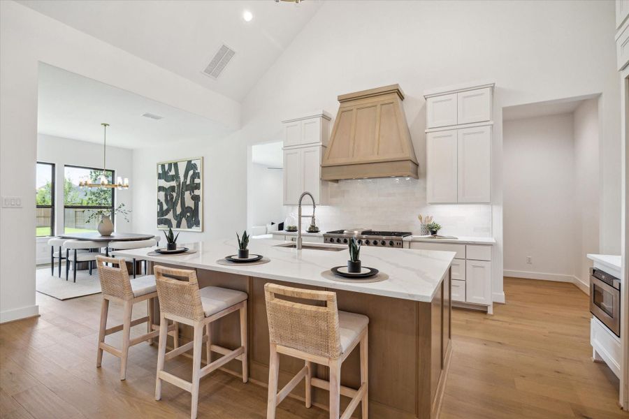 Chef's Kitchen with custom-built cabinetry, quartz countertops, high-end appliances, and island with seating space Chef's Kitchen with custom-built cabinetry, quartz countertops, high-end appliances, and island with seating space