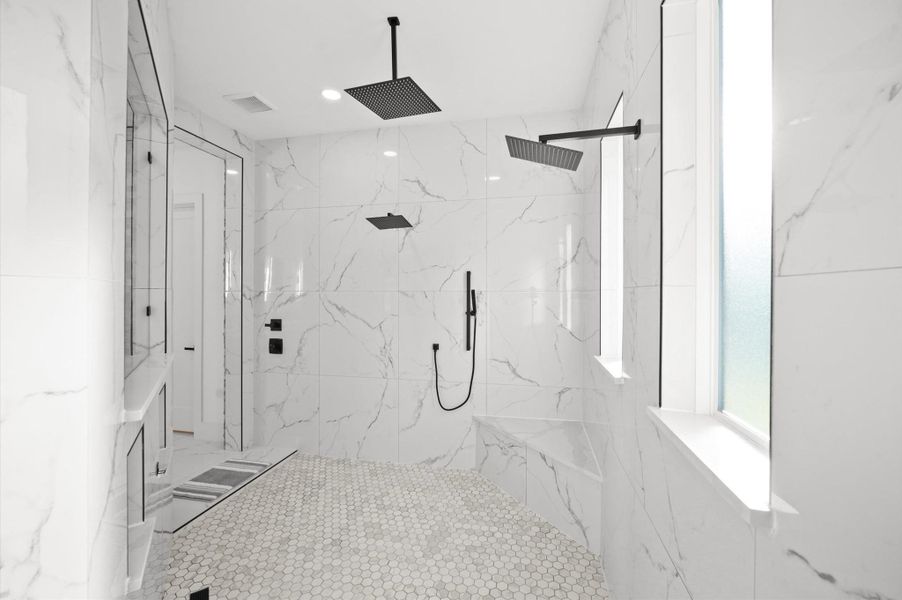 Oversized walk-in shower with premium tile finishes.