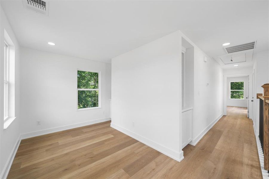 Hall featuring light wood-style flooring, attic access, and recessed lighting Hall featuring light wood-style flooring, attic access, and recessed lighting